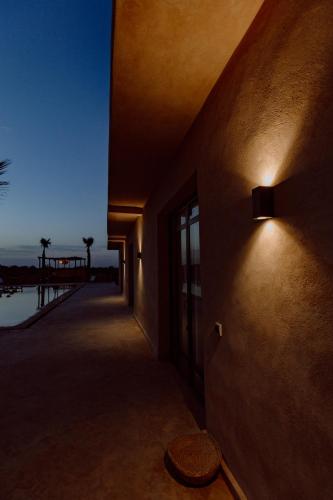 a light on the side of a building with a pier at Aghmat Lodge Guest house in Marrakech