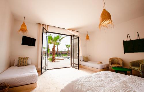 um quarto com uma cama e uma porta de vidro deslizante em Aghmat Lodge Guest house em Marrakech