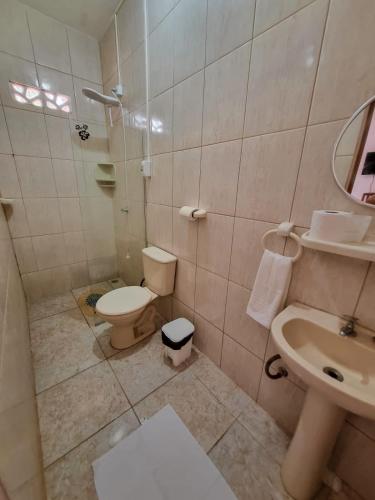 a bathroom with a toilet and a sink at Aloha Beach Guest House in Maragogi