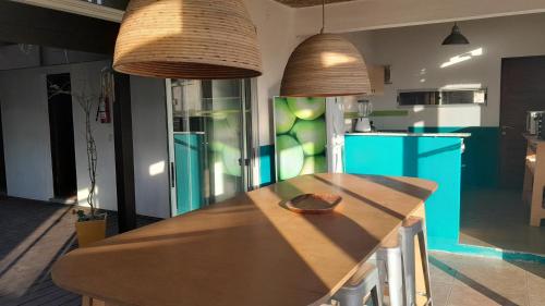 a kitchen with a wooden counter with two pendant lights at Balconada Beach ROOMS in La Paloma