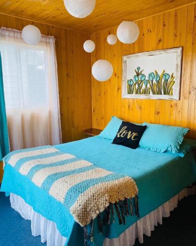 1 dormitorio con cama con almohada de amor en Cabañas Agroturismo Pupelde, en Ancud