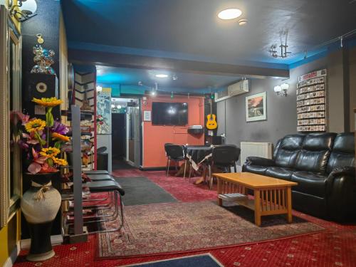 a living room with a leather couch and a table at City View Hotel Roman Road in London