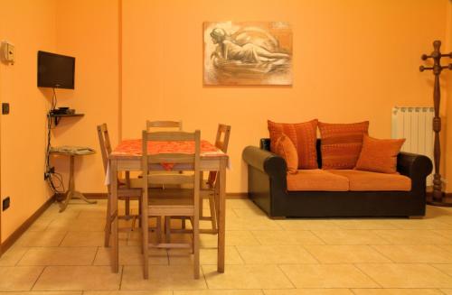 a dining room with a table and a couch at Agriturismo Il Melograno in Tessera