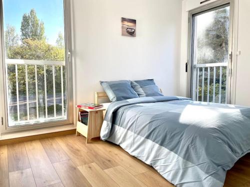 a bedroom with a bed and a large window at Friendly Bean in Cachan