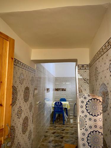 een kamer met een tafel en een blauwe stoel bij Dar Haniya in Rabat