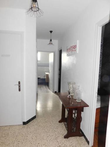 a hallway with a table with glasses on it at Gîte MMR 6 places avec cour clôturée 3 nuits mini in Saint-Saturnin