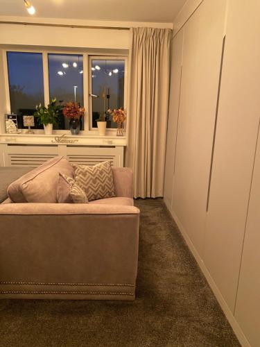ein Wohnzimmer mit einem Sofa und einem Fenster in der Unterkunft Niv’s Home away from Home in Kempston