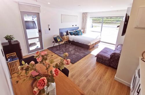 a living room with a bed and a table with roses at 37 Galaxy C studio in Lake Tekapo