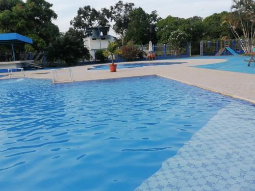 a large swimming pool with blue water at Hotel campestre la Maria in Villavicencio
