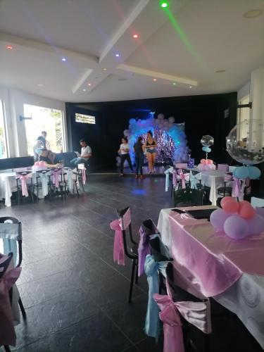 a room with tables and chairs and a dance floor at Hotel campestre la Maria in Villavicencio