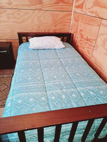 uma cama num quarto com uma almofada em Cabañas Tripanko Chiloe em Ancud
