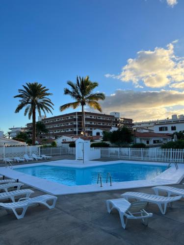 a swimming pool with lounge chairs and a resort at V Macaronesia in San Bartolomé de Tirajana