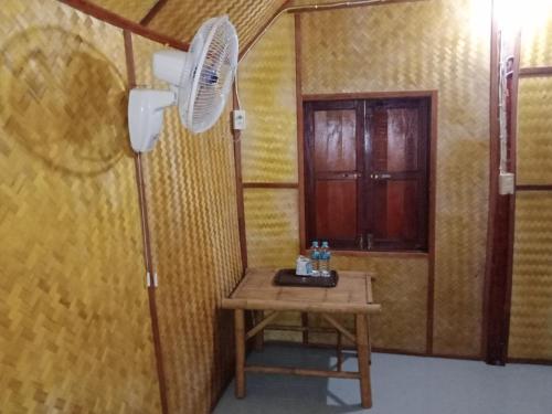 a room with a table and a fan at Breizh Cape Beach Bungalows in Ko Lanta