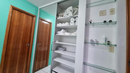 vestidor con estanterías blancas y espejo en Hospedagem residencial Recife Encantos Mil, en Recife