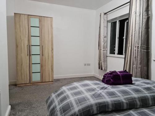 a bedroom with a bed with a purple bag on it at Impeccable 4-Bed House Near Manchester City Centre in Manchester