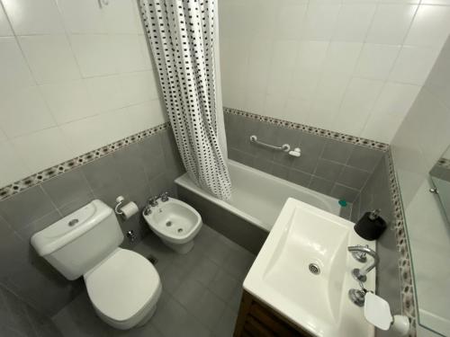 y baño con aseo blanco y lavamanos. en Tigre Center Tower F - Cochera, piscina y seguridad 24hs en Tigre