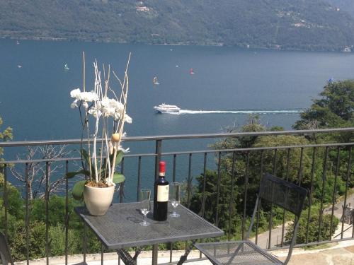 a table with a bottle of wine and a boat in the water at B&B Lago Maggiore in Cannobio