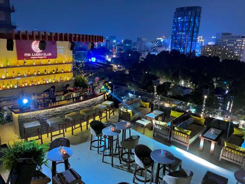 a view of a rooftop bar with tables and chairs at Happy Life Grand Hotel & Sky Bar in Ho Chi Minh City