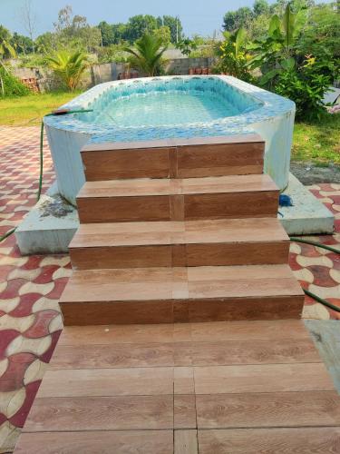 a staircase leading to a swimming pool with a wooden floor at Bay Front Home in Visakhapatnam