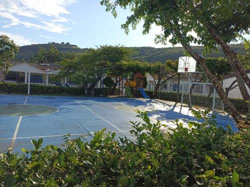 una pista de tenis con un aro de baloncesto. en Casa para disfrutar unos días en familia, en Girardot