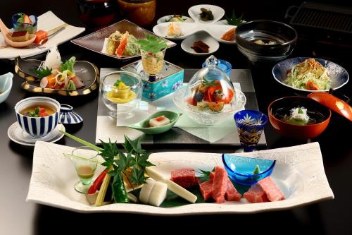 a table with many plates of food on it at Hotel Tamanoyu in Matsumoto