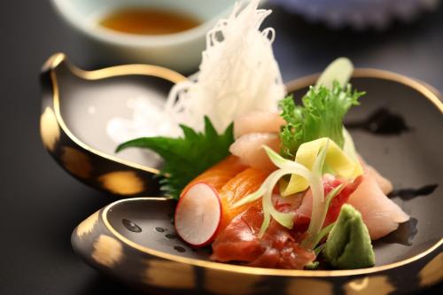 a bowl of food with sushi and rice on a table at Hotel Tamanoyu in Matsumoto