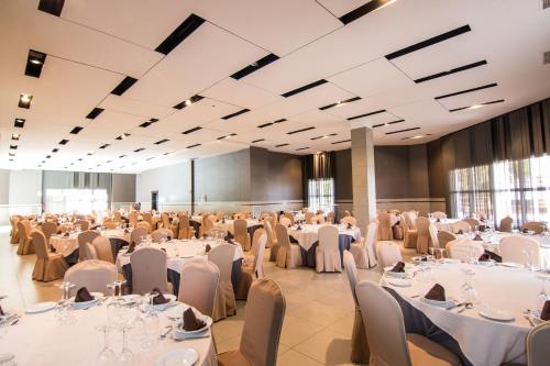 a large banquet hall with white tables and chairs at Hotel Abades Loja in Loja