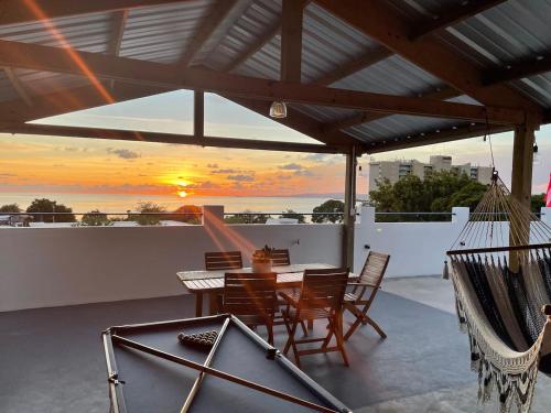 瓜尼卡的住宿－Palmeras Beach Apartments - Playa Santa，一个带桌椅的庭院,享有日落美景。