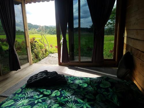 a bed in a room with a large window at Le Pandai in Bogor