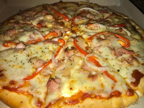 a pizza with cheese and red peppers on it at Chekesh Casa in Siquijor