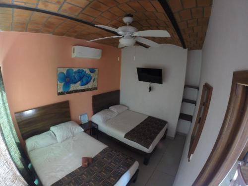 a bedroom with two beds and a ceiling fan at Kiramar los Peyotes in Rincon de Guayabitos