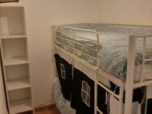 - une chambre avec des lits superposés et des étagères dans l'établissement Appartement cosy pour 4-6 pers, proche centre, parking, casier à ski, Cauterets - FR-1-234-294, à Cauterets