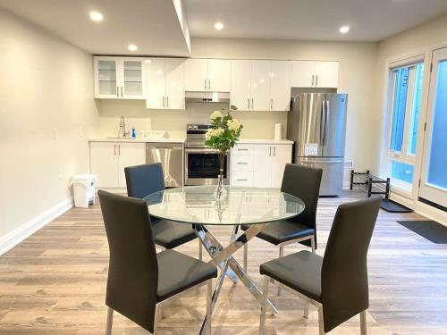 uma cozinha com uma mesa de vidro e cadeiras em Beautiful Walk out Basement Apartment in Pickering near Beach em Pickering