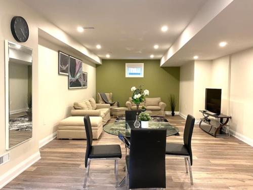 Beautiful Walk out Basement Apartment in Pickering near Beach في بيكرينغ: غرفة معيشة مع طاولة وكراسي وأريكة