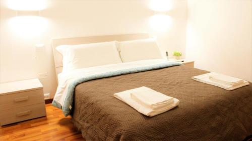 a bedroom with a large bed with two towels on it at Venice Suites in Mestre