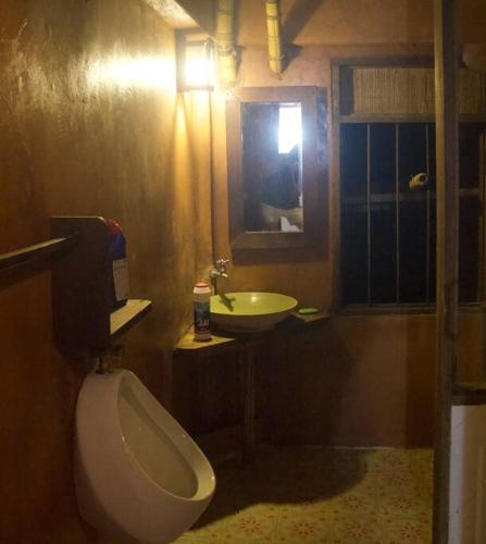 a bathroom with a white toilet and a sink at Greenleas, Cottage, Swimming Pool and Log Fire in Mae Chan