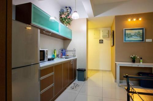 a kitchen with brown cabinets and a microwave at 2Bedrooms Maritime Luxury Seaview Suite 2-10pax in Jelutong