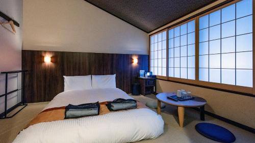 a bedroom with a large bed and a table at Tenseien Odawara Station Annex in Odawara