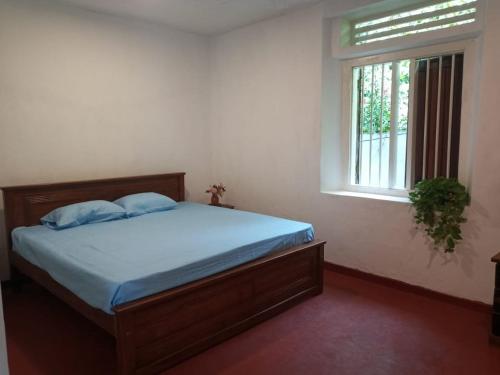 Bett in einem Zimmer mit einem Fenster und einem Bett sidx sidx sidx sidx in der Unterkunft Villa Arunodaya in Hikkaduwa