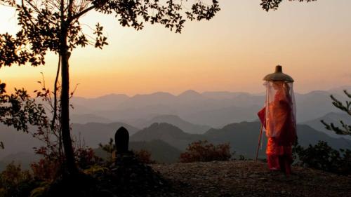 a person standing on top of a hill looking at the mountains at Kumano Kodo Nagano Guesthouse in Tanabe