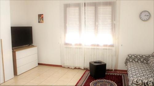 a living room with a television and a window with at Venice Suites in Mestre