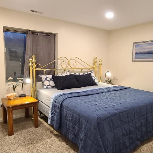 a bedroom with a bed with a blue blanket at Entire Huge Basement! Fast Wifi! Private Entrance! in Salt Lake City
