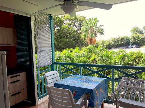 un patio con tavolo e sedie sul balcone. di Color Garden - Studio Martinique a Sainte-Anne