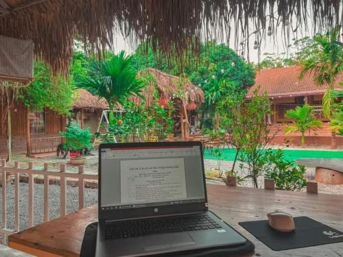 um computador portátil sentado em cima de uma mesa de madeira em Ninh Binh Bungalow Homestay em Ninh Binh