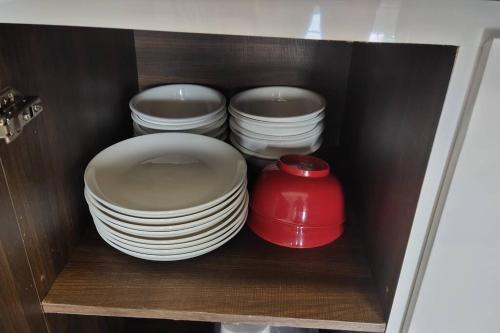 two stacks of plates and a red bowl in a cabinet at Kulai d putra suites beside ioiMall near JPO and Airport in Kulai