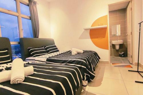 two beds in a small room with a window at Kulai d putra suites beside ioiMall near JPO and Airport in Kulai