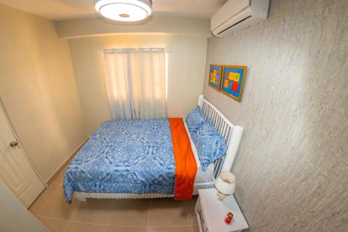um pequeno quarto com uma cama com um edredão azul em D' Yoko Village's em Pedernales