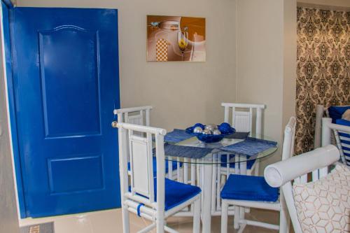 uma porta azul numa sala de jantar com mesa e cadeiras em D' Yoko Village's em Pedernales