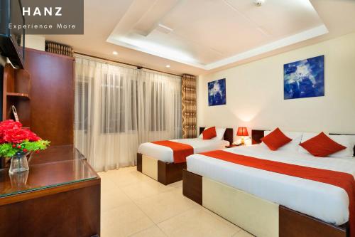 a hotel room with two beds and a desk at HANZ Beautiful Boutique Hotel Saigon in Ho Chi Minh City