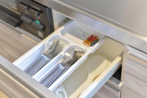 an open refrigerator with plates and utensils in it at GLASS Yamahana EAST in Minami-jūichijō